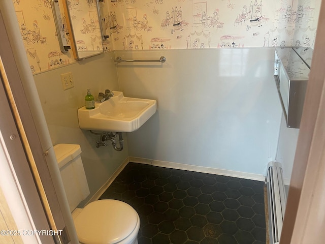 half bathroom featuring a baseboard heating unit, a sink, toilet, and wallpapered walls