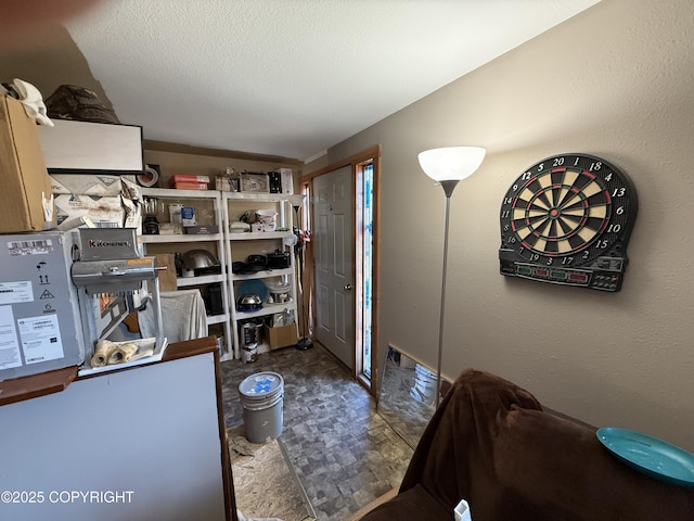 interior space with a textured wall and a textured ceiling