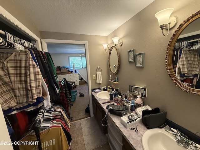 bathroom with a textured wall, a textured ceiling, and vanity