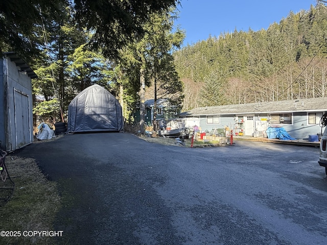 view of street featuring aphalt driveway and a gate