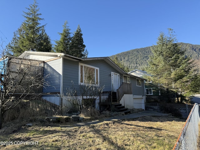 view of side of property with fence and a mountain view