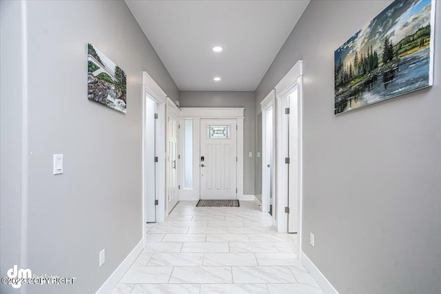 entryway with recessed lighting, marble finish floor, and baseboards