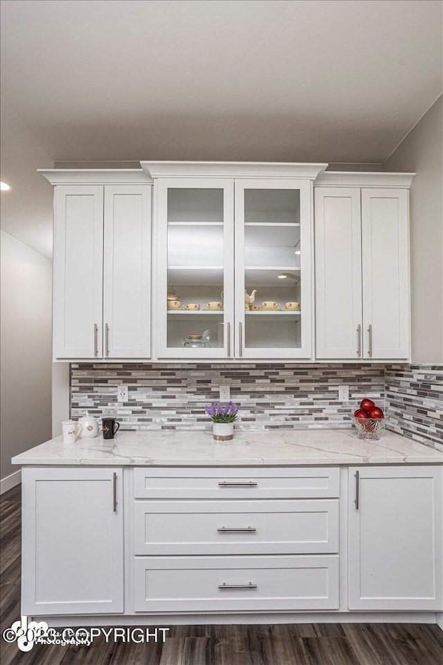 bar featuring dark wood-style floors and tasteful backsplash