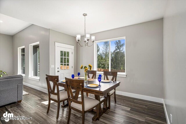 dining space featuring baseboards, dark wood finished floors, and a notable chandelier