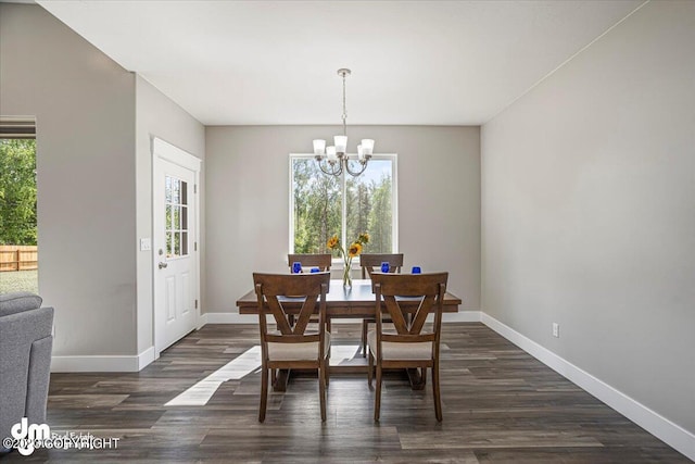 dining area featuring dark wood-style floors, baseboards, and a notable chandelier