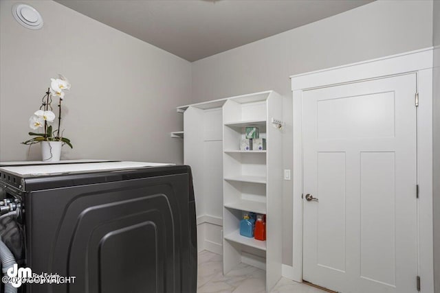 clothes washing area featuring laundry area, baseboards, washer / clothes dryer, and marble finish floor