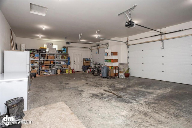 garage with freestanding refrigerator and a garage door opener