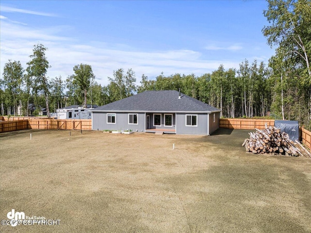 rear view of house with a fenced backyard