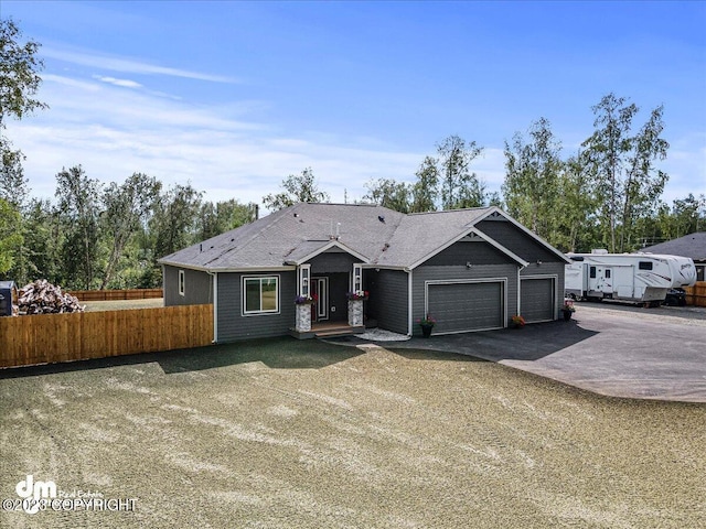 ranch-style home with driveway, an attached garage, and fence