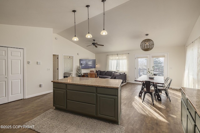 kitchen with decorative light fixtures, french doors, a kitchen island, and baseboards