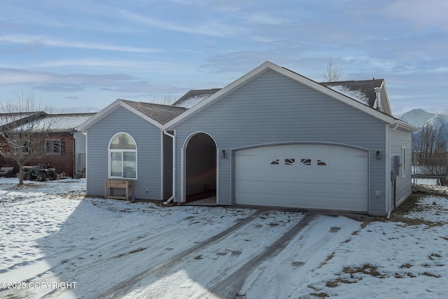 single story home featuring a garage and roof with shingles