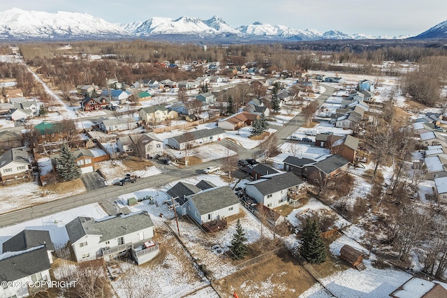 snowy aerial view with a residential view and a mountain view