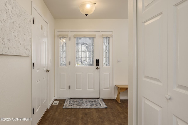 foyer entrance with visible vents and dark wood-type flooring