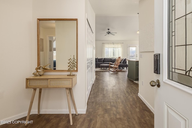 corridor featuring dark wood-type flooring and baseboards