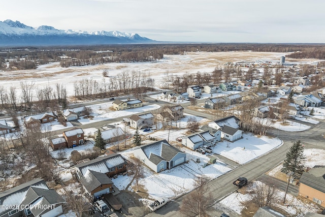 snowy aerial view with a residential view and a mountain view