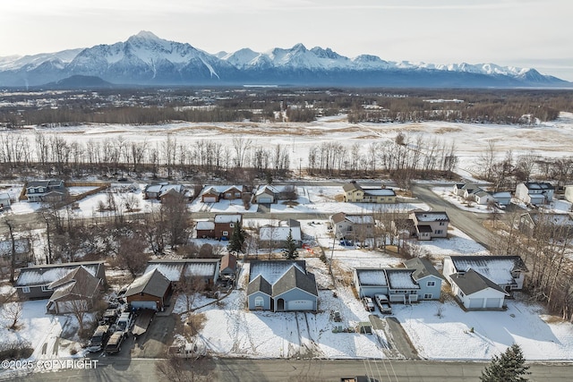 snowy aerial view featuring a residential view and a mountain view