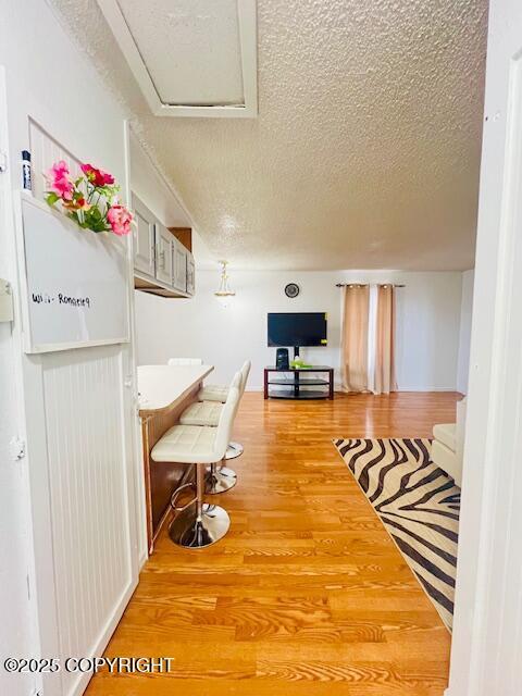 hallway with a textured ceiling and wood finished floors