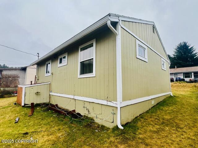 view of side of property featuring crawl space and a lawn