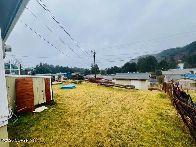 view of yard with an outbuilding, fence, and a shed