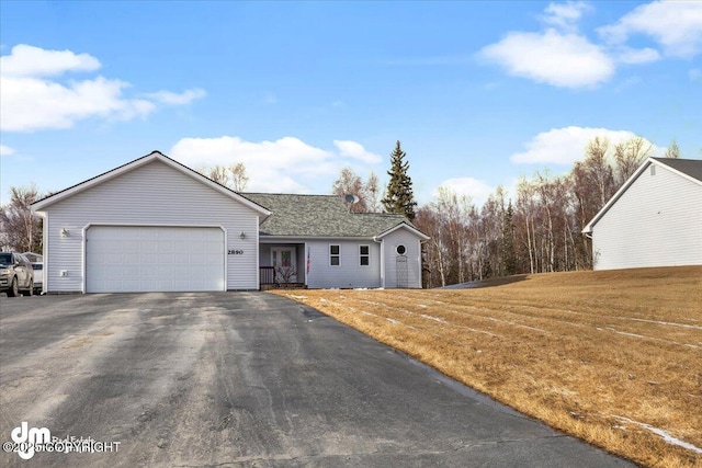 ranch-style house featuring a garage, driveway, and a front lawn