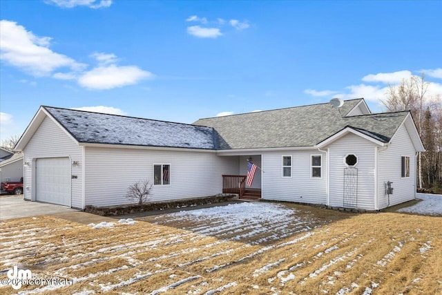 single story home featuring a garage, concrete driveway, and roof with shingles