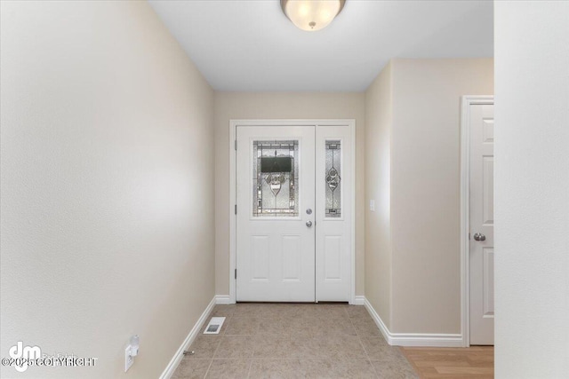 doorway to outside featuring baseboards and visible vents