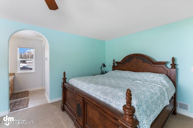 bedroom with arched walkways, light carpet, a ceiling fan, visible vents, and baseboards