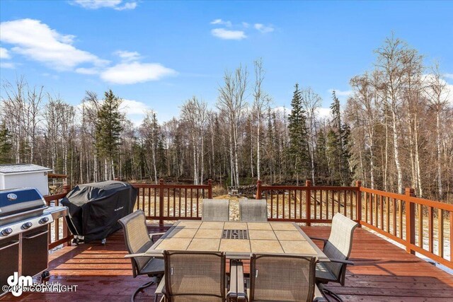 deck with outdoor dining area and area for grilling