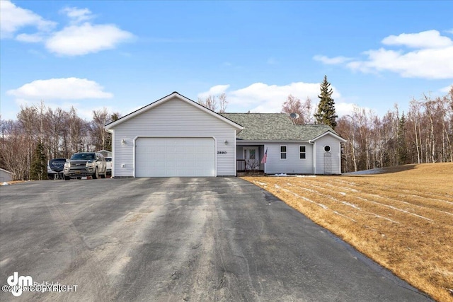 single story home featuring driveway, an attached garage, and a front yard