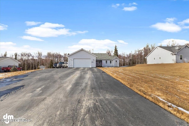 ranch-style house with an attached garage, driveway, and a front lawn