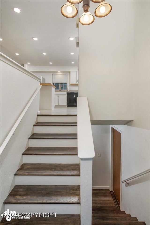 staircase with wood finished floors and recessed lighting