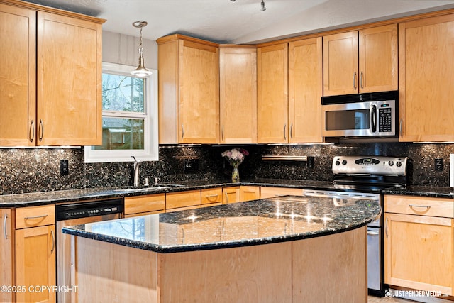 kitchen with light brown cabinets, appliances with stainless steel finishes, and a center island