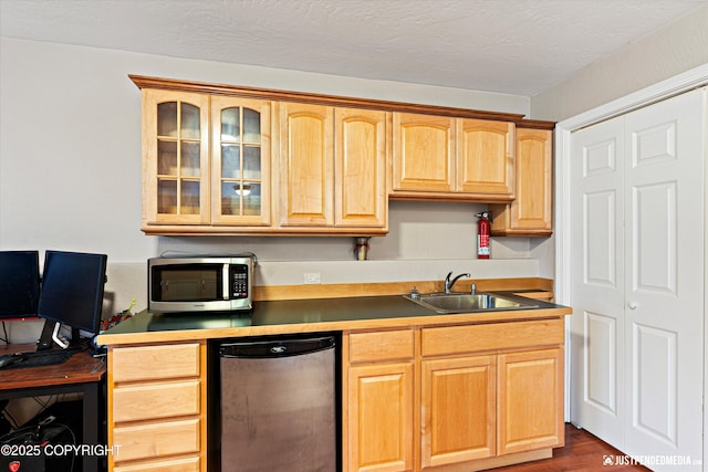 kitchen with glass insert cabinets, stainless steel microwave, fridge, light brown cabinets, and a sink