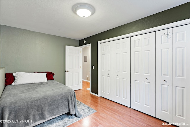 bedroom featuring light wood finished floors, a textured ceiling, and a closet