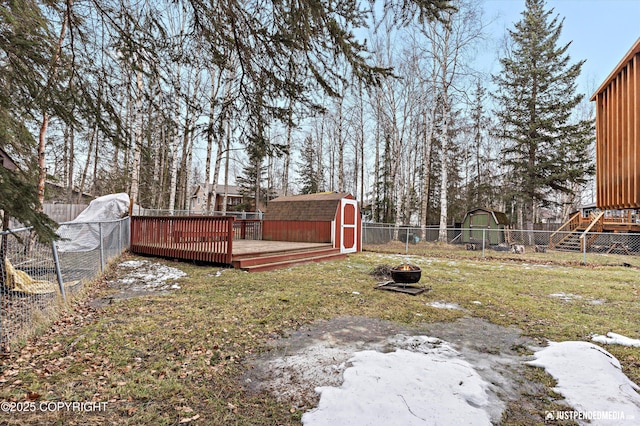 view of yard featuring a fenced backyard, a storage unit, a deck, and an outdoor structure