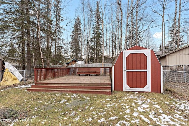 view of yard featuring a storage shed, an outbuilding, a fenced backyard, and a wooden deck