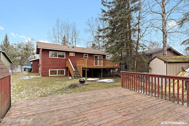 wooden terrace with stairs, fence, and a lawn