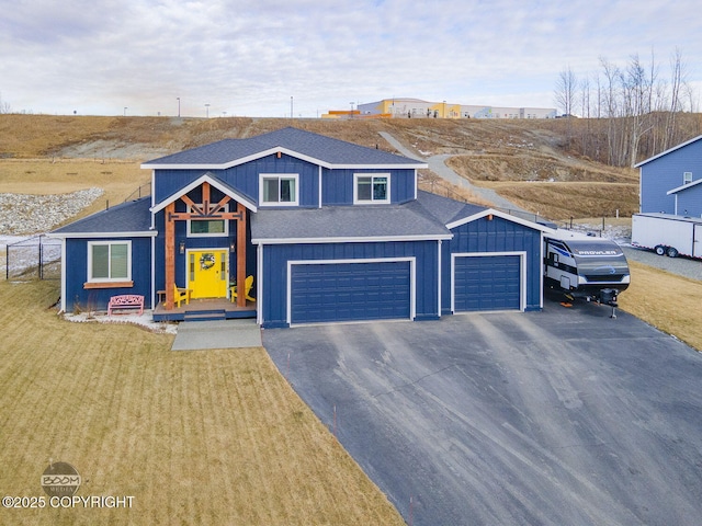 view of front of home featuring a front yard, roof with shingles, driveway, and fence