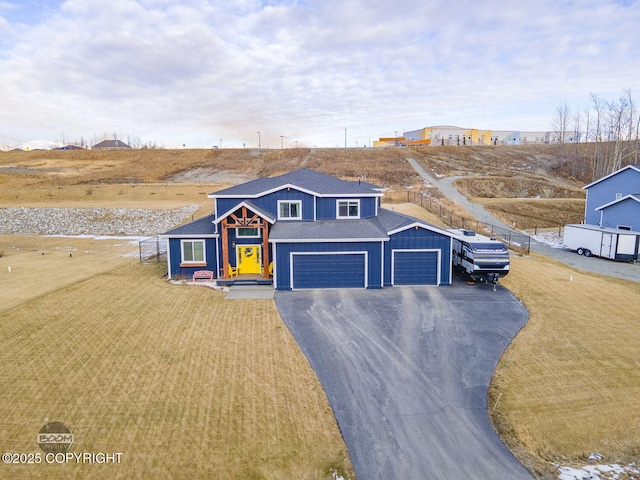 view of front of house featuring driveway, a shingled roof, fence, and a front lawn