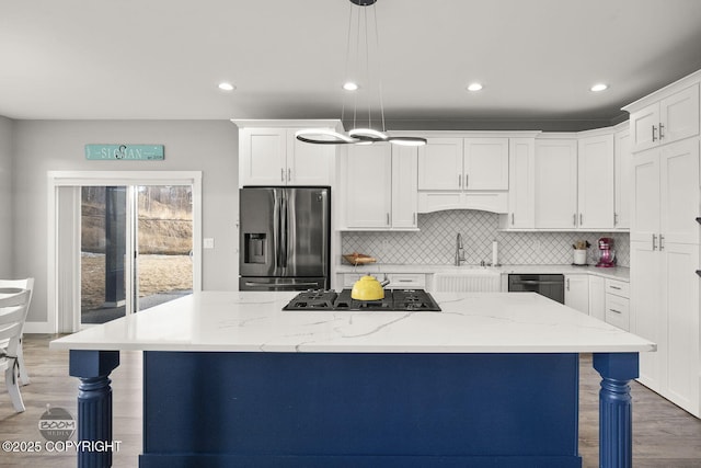 kitchen featuring gas cooktop, white cabinets, a breakfast bar area, and stainless steel fridge with ice dispenser