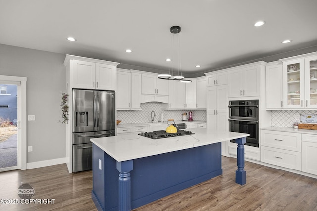 kitchen with black appliances, a kitchen bar, white cabinetry, and dark wood-type flooring