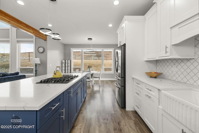 kitchen with freestanding refrigerator, black gas cooktop, blue cabinetry, white cabinetry, and backsplash