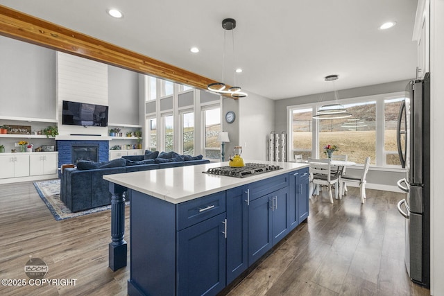 kitchen featuring stainless steel appliances, dark wood finished floors, light countertops, and blue cabinets