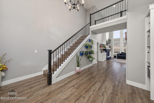 entryway featuring baseboards, stairway, and wood finished floors