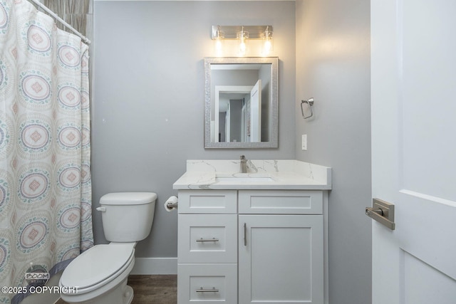 bathroom featuring baseboards, a shower with shower curtain, toilet, wood finished floors, and vanity