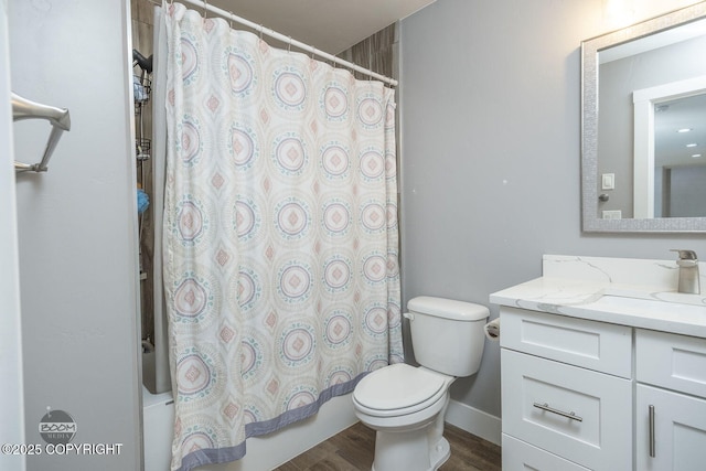 full bathroom with baseboards, toilet, wood finished floors, shower / bath combo with shower curtain, and vanity