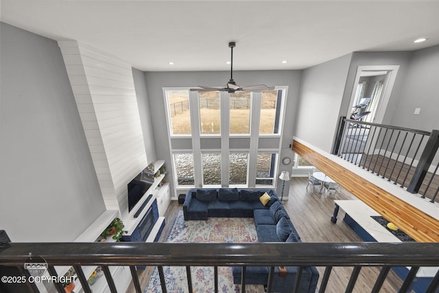 living area featuring baseboards, wood finished floors, and recessed lighting