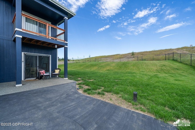 view of yard with a patio area, a fenced backyard, a balcony, and a rural view