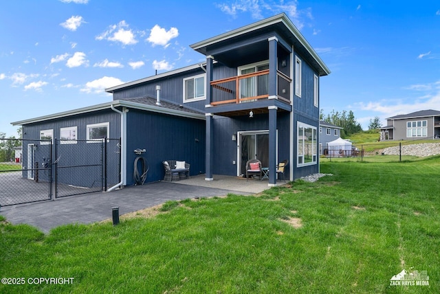 back of property with a lawn, a patio, a balcony, a gate, and fence