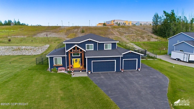 view of front facade featuring aphalt driveway, board and batten siding, a front yard, fence, and a garage